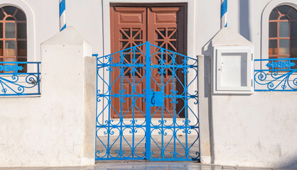 Fototapeta na wymiar Blue iron gate at a Greek Orthodox church at Oia town on the island of Santorini