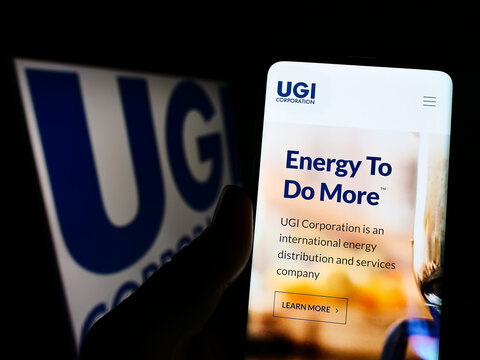 Stuttgart, Germany - 10-18-2022: Person holding cellphone with webpage of US energy company UGI Corporation on screen in front of business logo. Focus on center of phone display.