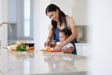 Cooking food, mother and child cutting vegetables helping prepare healthy vegan diet dinner in the kitchen at home learning and having fun. Happy woman and girl kid family teaching culinary skills