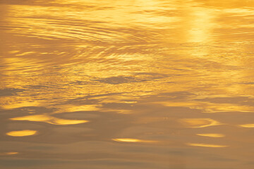the water surface of a river or lake with sun glare at sunset