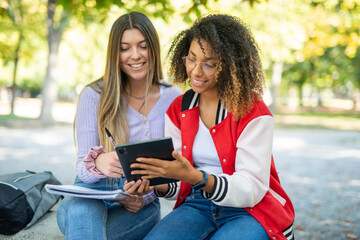 Fototapeta premium Female college students studying together in a park