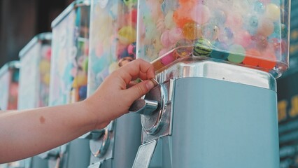 Caucasian Kid Buying Bouncy Rubber Ball in Toy Vending Machine at Amusment Park or Festival