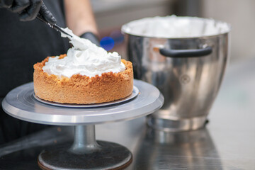 pastry chef designer filling a pie crust with lemon flavour meringue mousse cheese cream with...