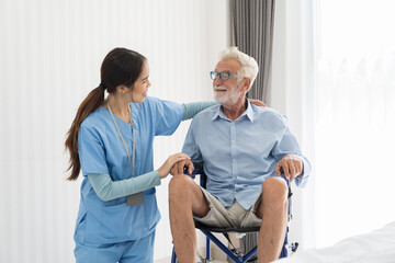 Obraz premium Asian young female nurse taking care elderly patient man on wheelchair in room at hospital ward