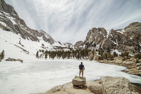 Rear view of hiker looking at view while standing on rocks