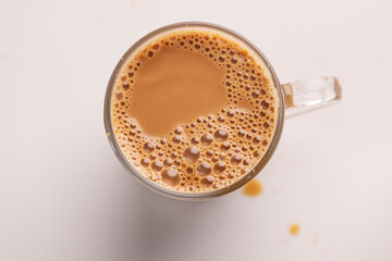 Cup of tea with foam on white.