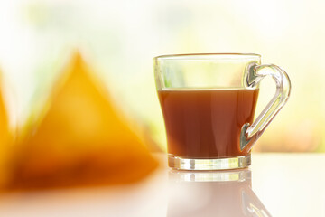 Plate of hot Samosas and cup of tea on table 