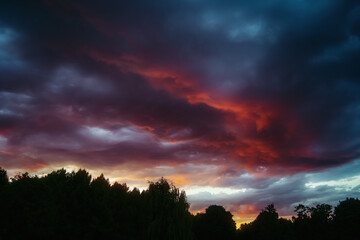 Obraz premium Dramatic clouds in the sky at beautiful red sunset. Nature landscape background