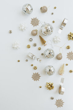 Golden confetti and Christmas tree balls on white background. Flat lay, top view Christmas holidays background