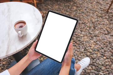 Top view mockup image of a woman holding digital tablet with blank white desktop screen in cafe