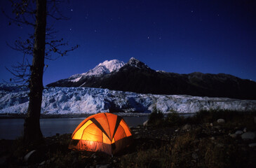A camper's tent glows near the face of Child's Glacier in the Copper River Delta area of Alaska.