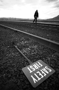 A man walking down railroad tracks.