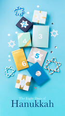 Jewish holiday Hanukkah concept - Gift boxes, stars of David and white candles on blue paper...