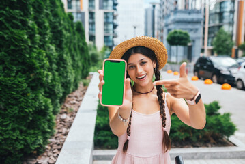 woman showing modern smartphone with green screen for replacement