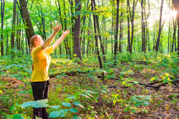 Happy woman outstretching hands to sun