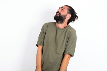 Obraz premium young bearded hispanic man wearing green T-shirt over white background very happy and excited about new plans.