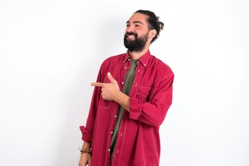 young bearded hispanic man wearing red overshirt over white background Pointing aside worried and nervous with forefinger, concern and surprise concept.