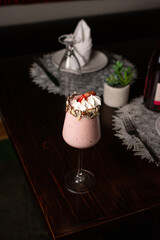 Strawberry milkshake with cream and chopped almonds