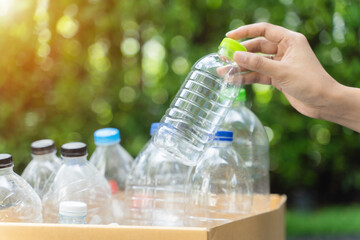 Carry water plastic bottles into garbage box trash in park, Concept of reuse, reduce, recycle to save the environment.
