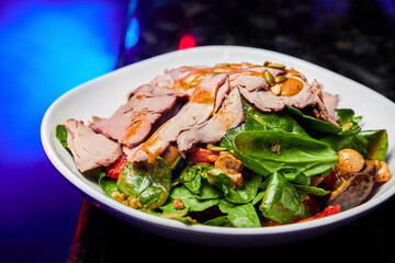 Salad with veal, spinach, vegetables and pumpkin seeds