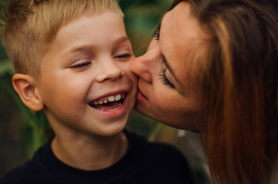 Close -up young mother hugs her little pretty son outdoor