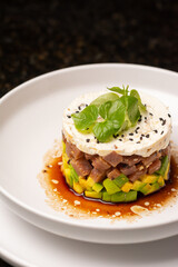 Tuna tartar. Tuna cut into small cubes mixed with soy and spicy and avocado bed

