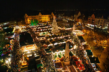 Traditional Christmas market in Erfurt, Thuringia in Germany. With xmas tree, pyramide and sales and food stands on late evening or night. - obrazy, fototapety, plakaty
