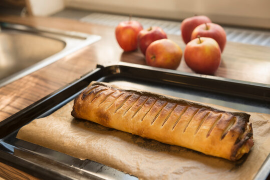 Close-up of apple strudel with apples on kitchen counter, Munich, Bavaria, Germany