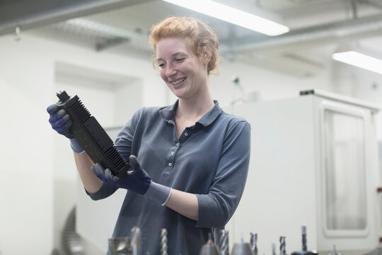 Young female engineer looking at machine part in an industrial plant, Freiburg im Breisgau, Baden-Württemberg, Germany