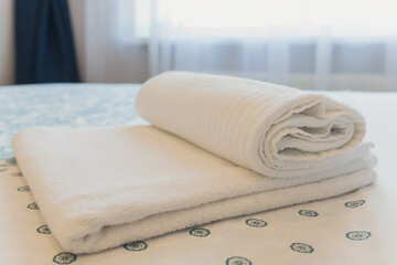 Bath towels on the bed of hotel bedroom.