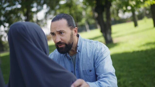 Closeup of middle-eastern man yelling at his wife outdoors, abusive relationship