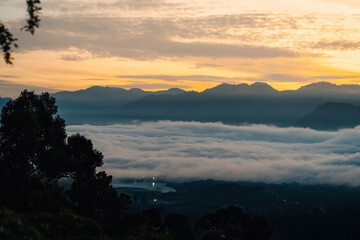 Sea clouds during golden sunrise near the rainforest trees in Lenggong, Perak.