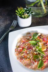 Fish carpaccio. Finely sliced ​​fish. Tuna and needle fish. Garnished with Olive Oil and Capers