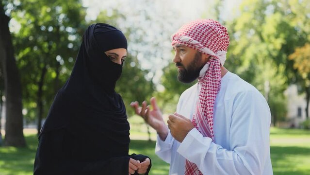 Arab man in white dress talking down to his wife, women discrimination