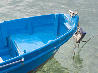 Small blue fishing boat docked in the harbor. - 541019790