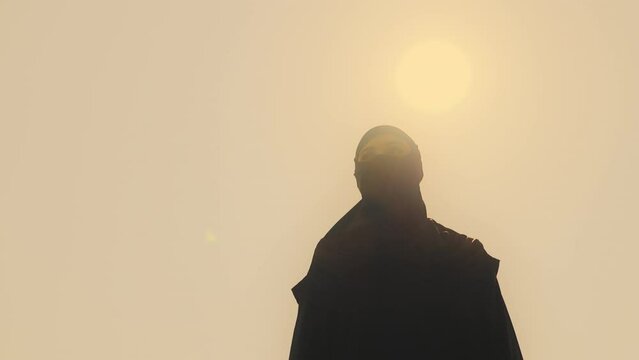 Muslim woman in Arab traditional dress wandering in desert, native land, sun