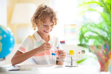 Child with solar system model. Kids planetarium.