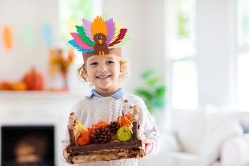 Child on Thanksgiving. Kid with autumn turkey hat.