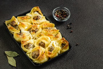 Mushroom sausage stuffed pasta shells in cast iron skillet. Top view, copy space, flat lay.