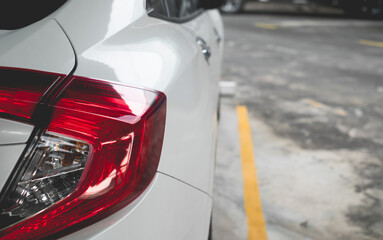 Rear white car in parking cars. Orderliness parked inside the line.