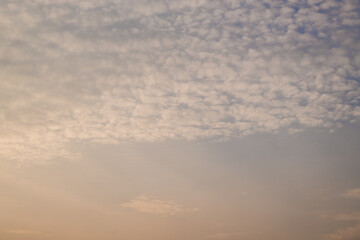 Altocumulus clouds with blue sky in the morning. Middle level layer clouds, extraordinary cloud formation, winter season is coming concept.