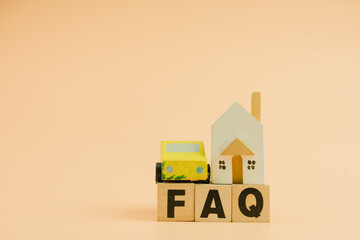 FAQ concept on wooden cubes and mini home and car. Wood toy car and wood toy home with FAQ.
