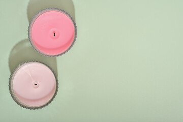 two wax candles over green background. fragrances for ambient home. natural coconut wax candles...
