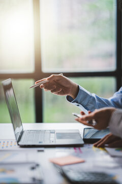 Young colleagues discussing business and price chart analyzes business people on the table great in modern coworking office teamwork concept. Calculate personal tax for customers