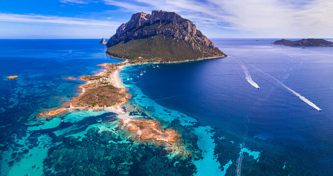 Aerial Panorama of Tavolara Island and Spalmatore di Terra Beach, Majestic Limestone Mountain Rising from Turquoise Sea in Sardinia, Italy, Mediterranean Aesthetic.