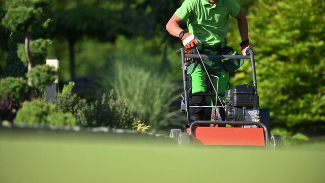 Gardener Pushing Gasoline Lawn Aerator and Preparing Soil For Nature Grass Turf Installation