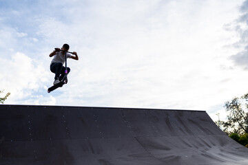 boy jumping with his scooter