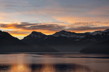 Fototapeta premium Beautiful sunset behind the mountions at the lake lucerne with some clouds