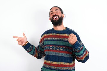 Naklejka premium Cheerful Caucasian man with beard wearing sweater over white background showing copy space ad celebrating luck