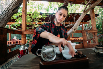 The tea ceremony. Woman pours water in a tea bowl.